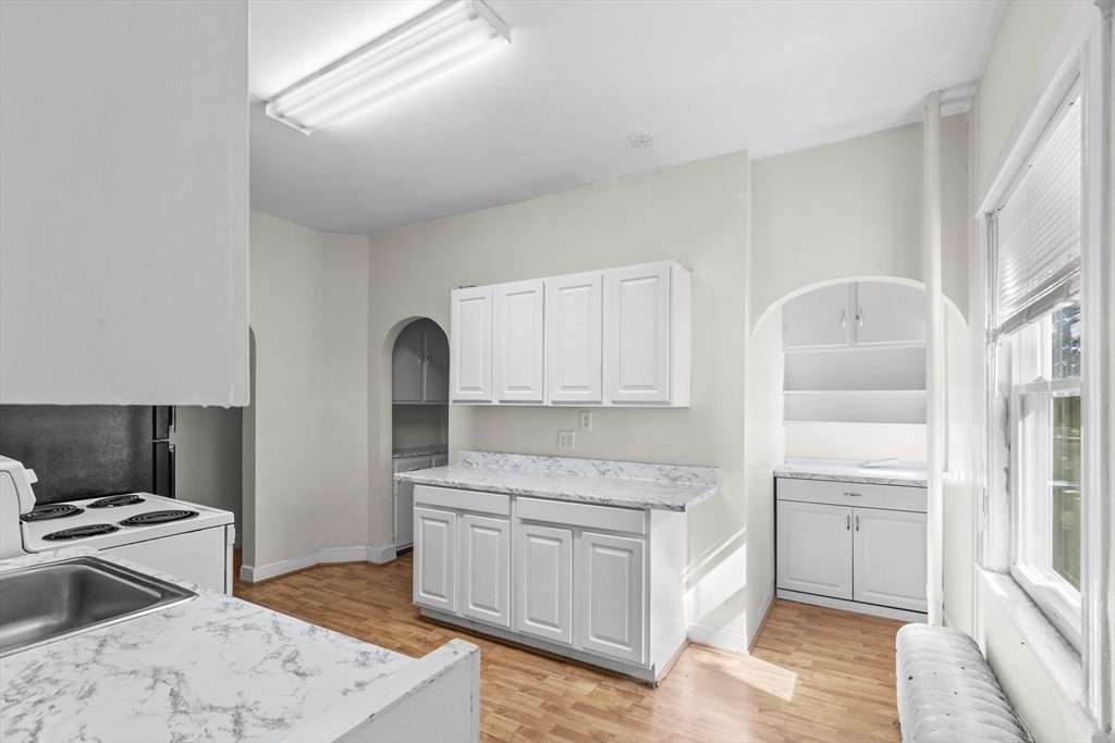 227 Winchester Street, Unit A Brookline, MA 02446 - Photo 7 of 18 a kitchen with a sink stove and cabinets