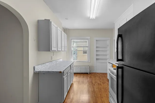 a kitchen with granite countertop a sink a stove and cabinets