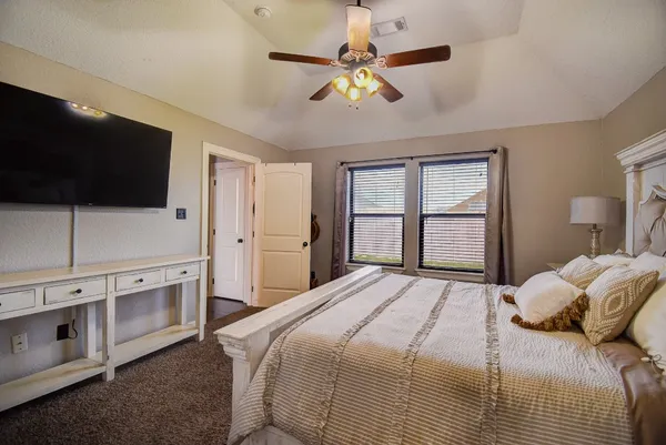 a bedroom with a large bed and a flat screen tv