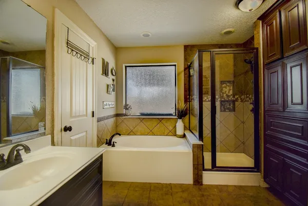 a bathroom with a tub sink and mirror
