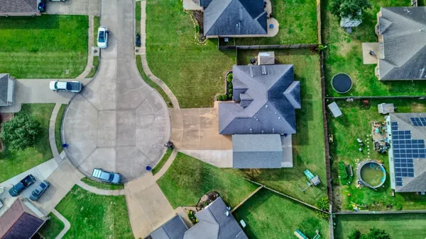an aerial view of a house with garden space and street view