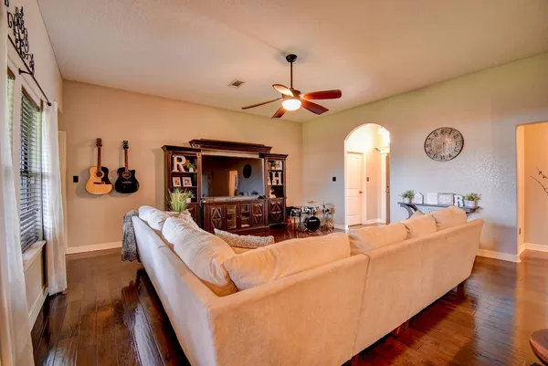 a living room with furniture a clock and a window