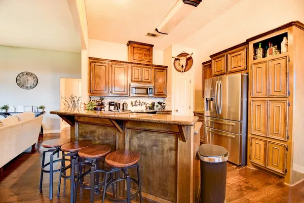 a kitchen with stainless steel appliances granite countertop a refrigerator and microwave