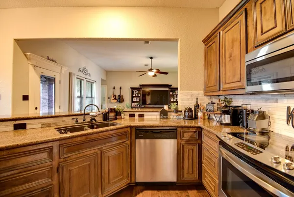 a kitchen with stainless steel appliances a sink stove and cabinets