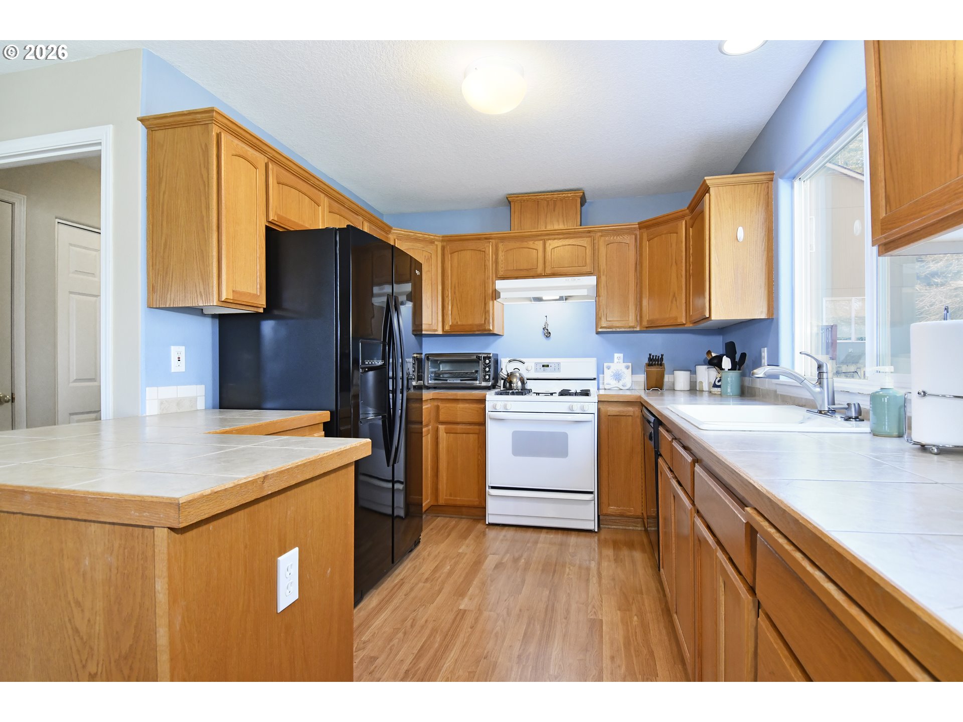 38029 Marcella Court Sandy, OR 97055 - Photo 10 of 29 a kitchen with a sink a stove a refrigerator and a cabinets