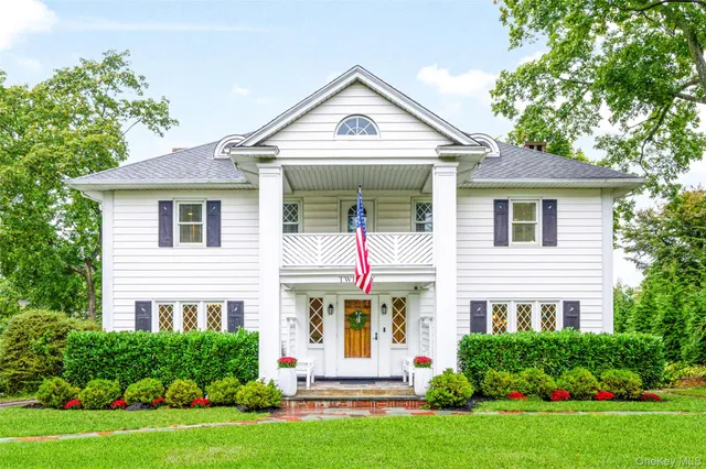 a front view of a house with a yard and trees