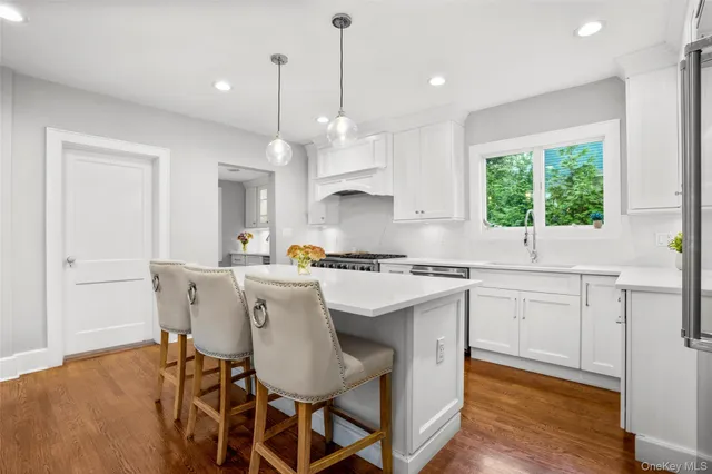 a kitchen with a dining table chairs sink and cabinets