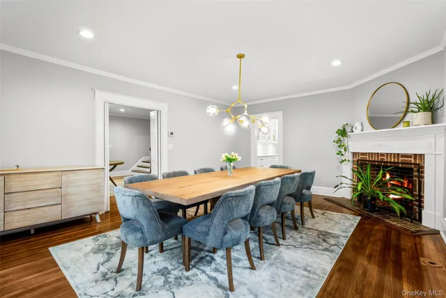 a dining room with furniture a rug a fireplace and a chandelier