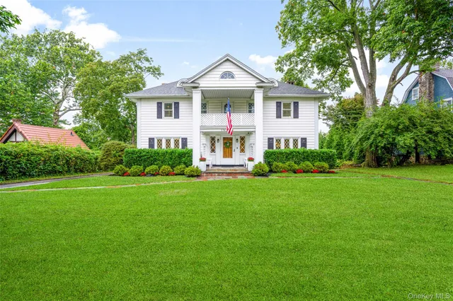 a front view of a house with a yard and green space