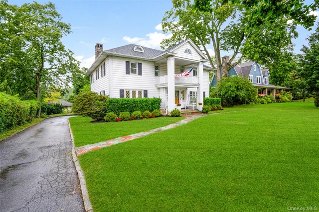 a front view of a house with a yard and trees