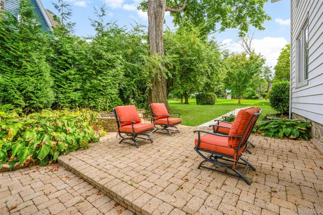 an outdoor sitting area with furniture and garden