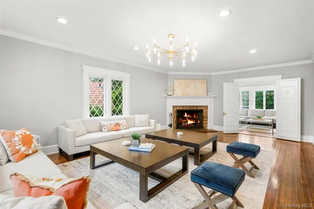a living room with furniture a fireplace and a chandelier