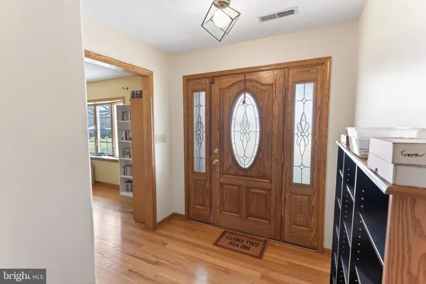 a large kitchen with kitchen island granite countertop a stove a sink and dishwasher wooden cabinets with wooden floor