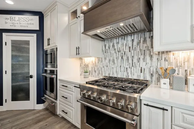 a kitchen with stainless steel appliances granite countertop a stove and a refrigerator
