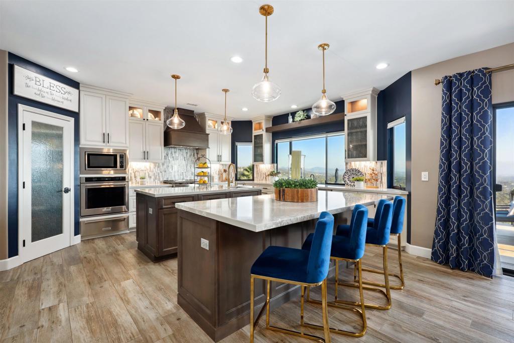 1966 Las Lomas Vista, CA 92084 - Photo 18 of 48 a kitchen with stainless steel appliances kitchen island granite countertop a table chairs and a refrigerator