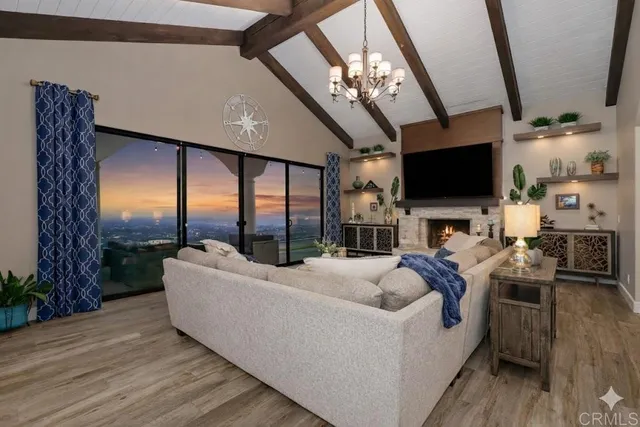 a living room with furniture a flat screen tv and a floor to ceiling window