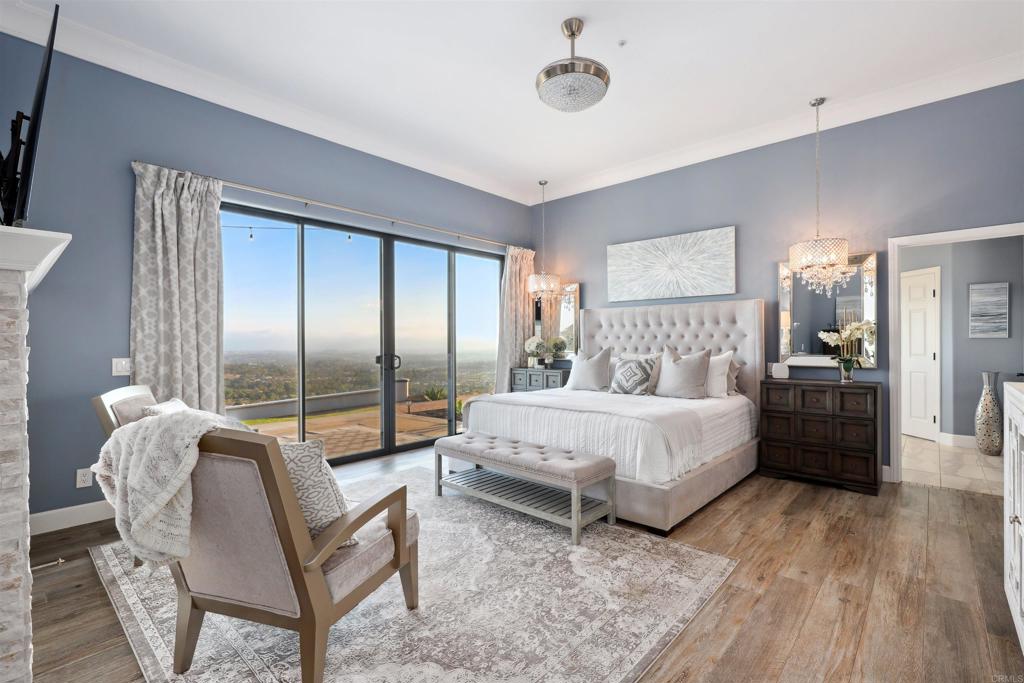 1966 Las Lomas Vista, CA 92084 - Photo 27 of 48 a spacious bedroom with a bed and a chandelier