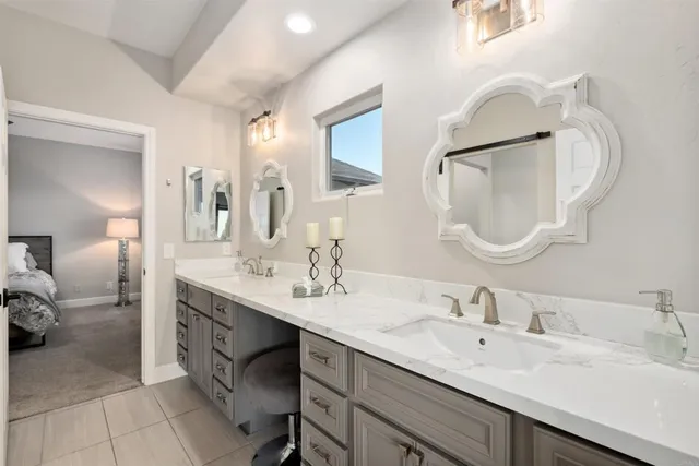 a en suite bathroom with a double vanity sink and a mirror