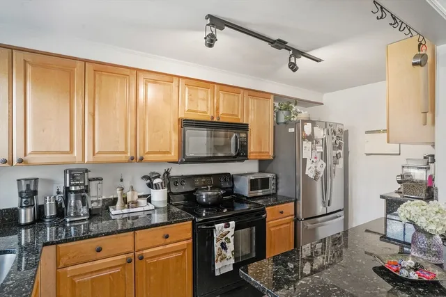 a kitchen with stainless steel appliances granite countertop a stove a sink dishwasher a refrigerator and cabinets with wooden floor