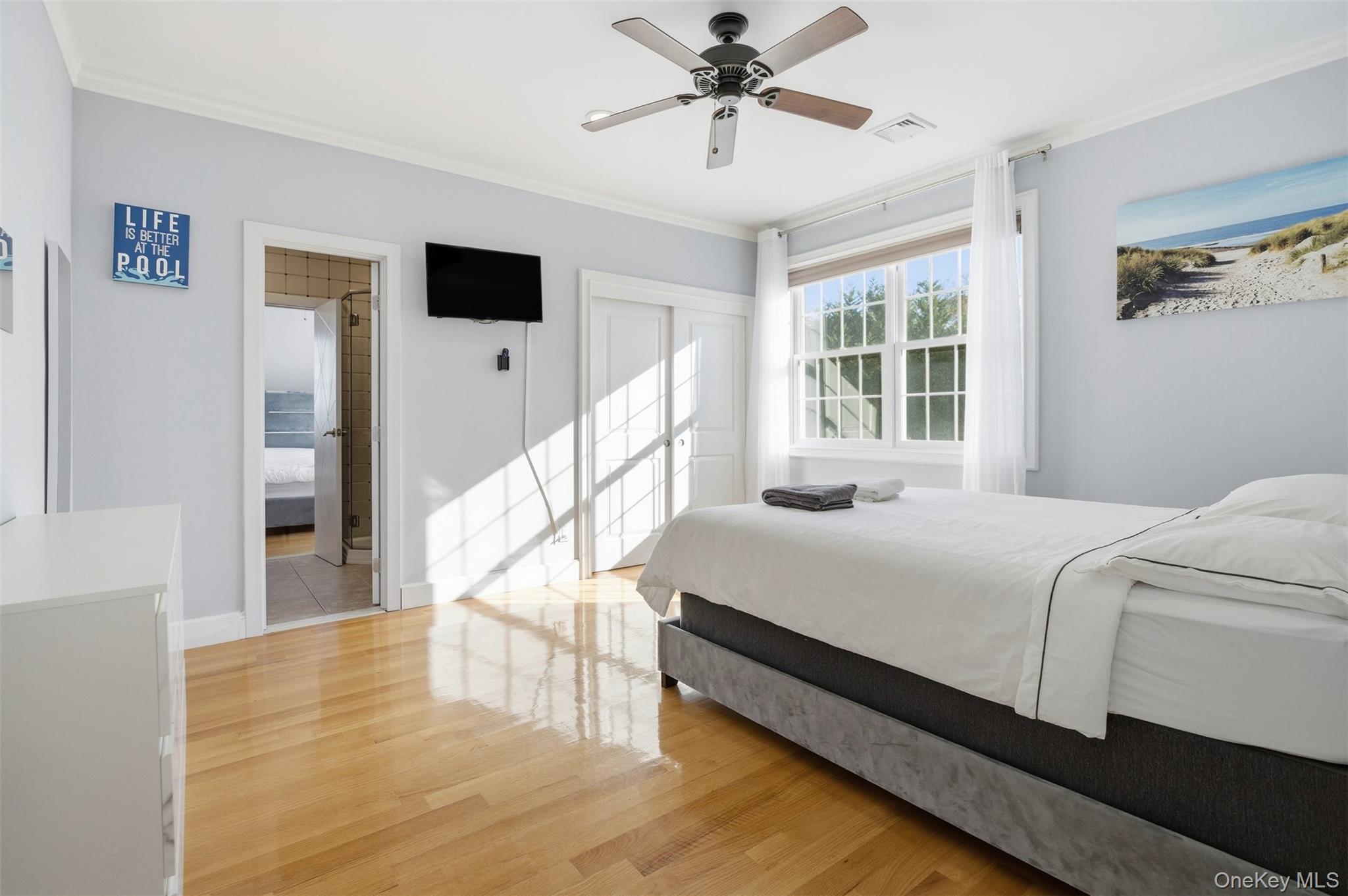 33 A Newtown Road Hampton Bays, NY 11946 - Photo 35 of 50 Bedroom with ornamental molding, light wood finished floors, a closet, and ceiling fan