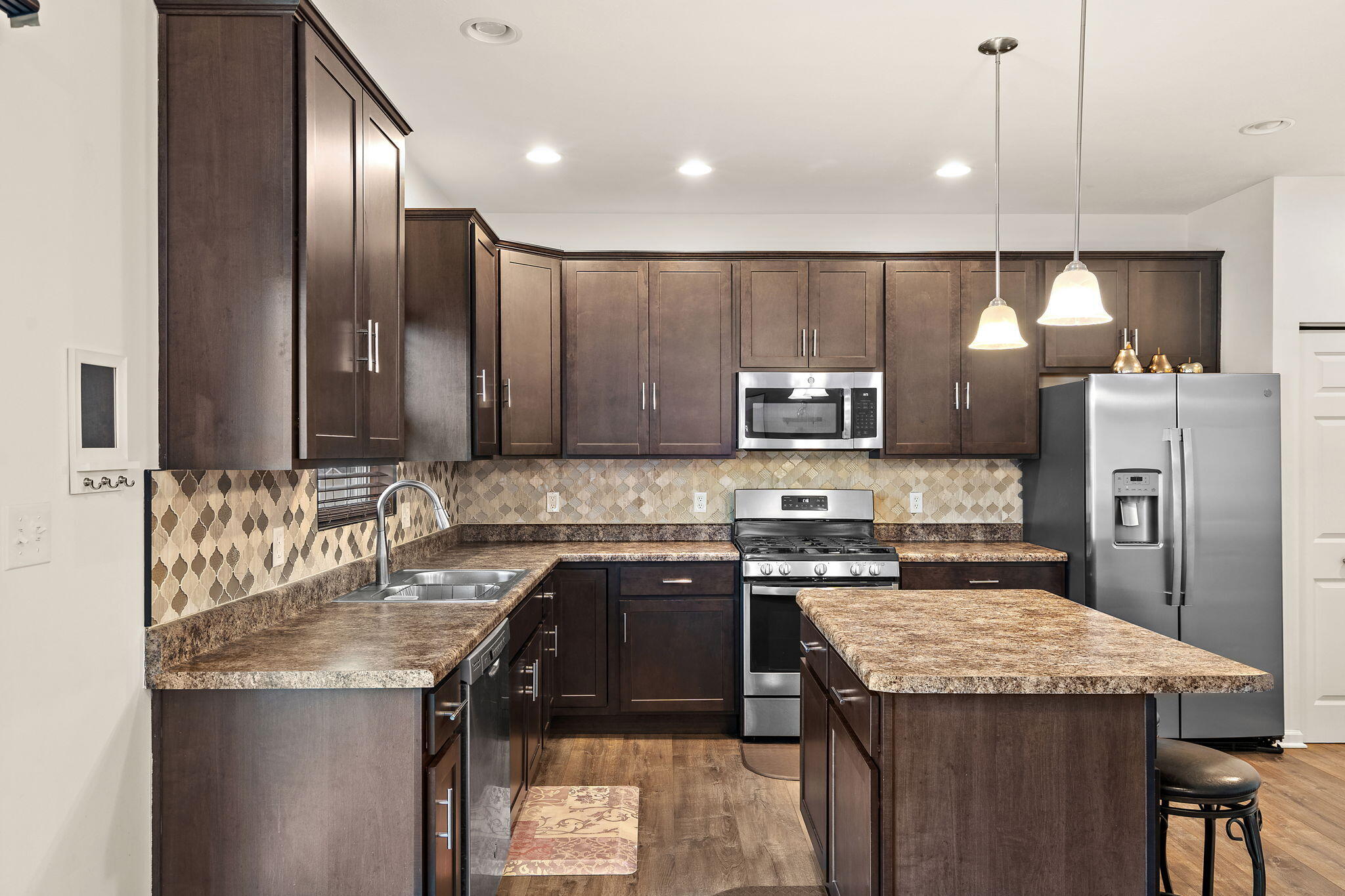 2434 Jupiter Street Portage, IN 46368 - Photo 13 of 30 a kitchen with kitchen island granite countertop stainless steel appliances a sink stove and refrigerator