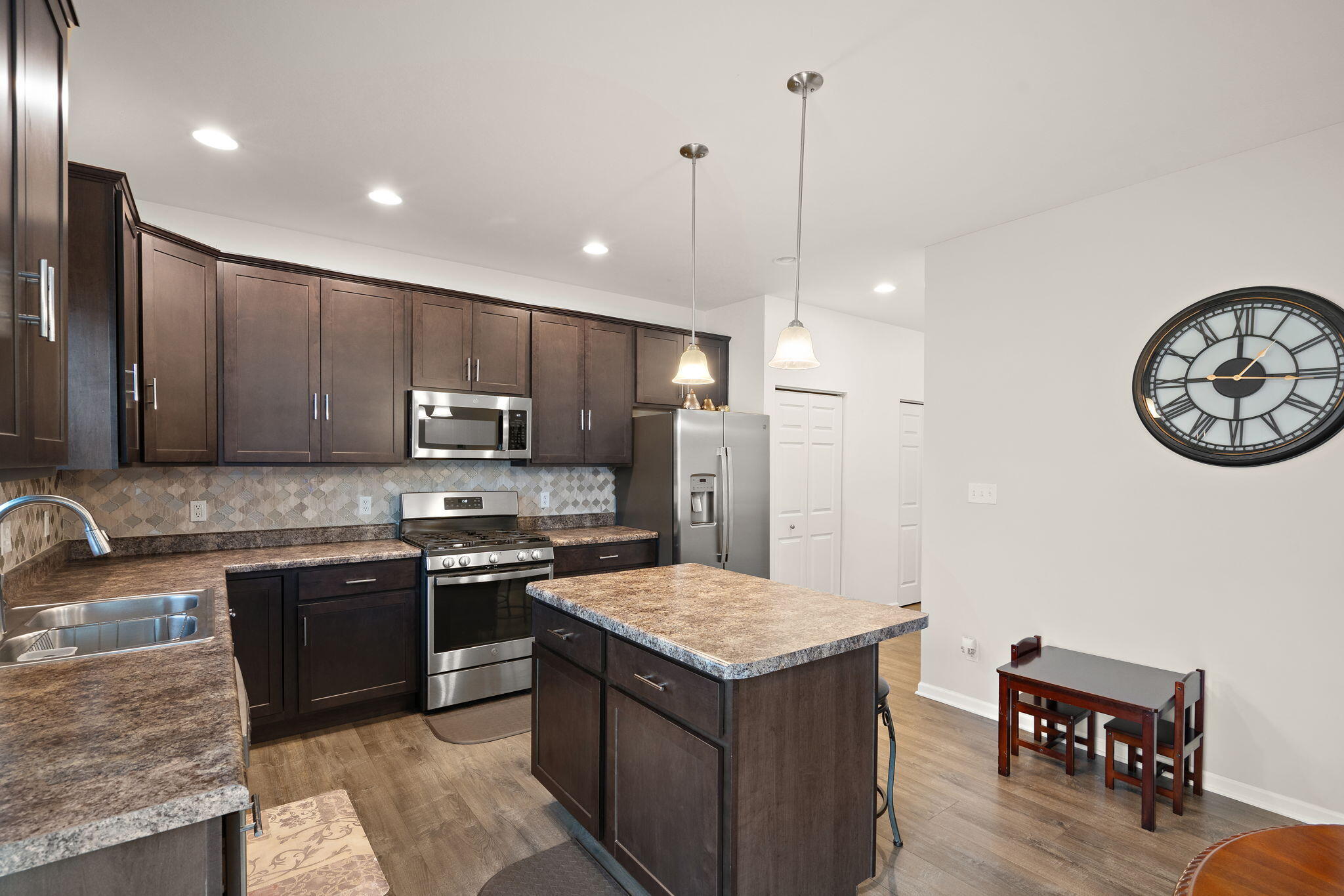 2434 Jupiter Street Portage, IN 46368 - Photo 14 of 30 a kitchen with kitchen island granite countertop a sink a counter top space appliances and cabinets