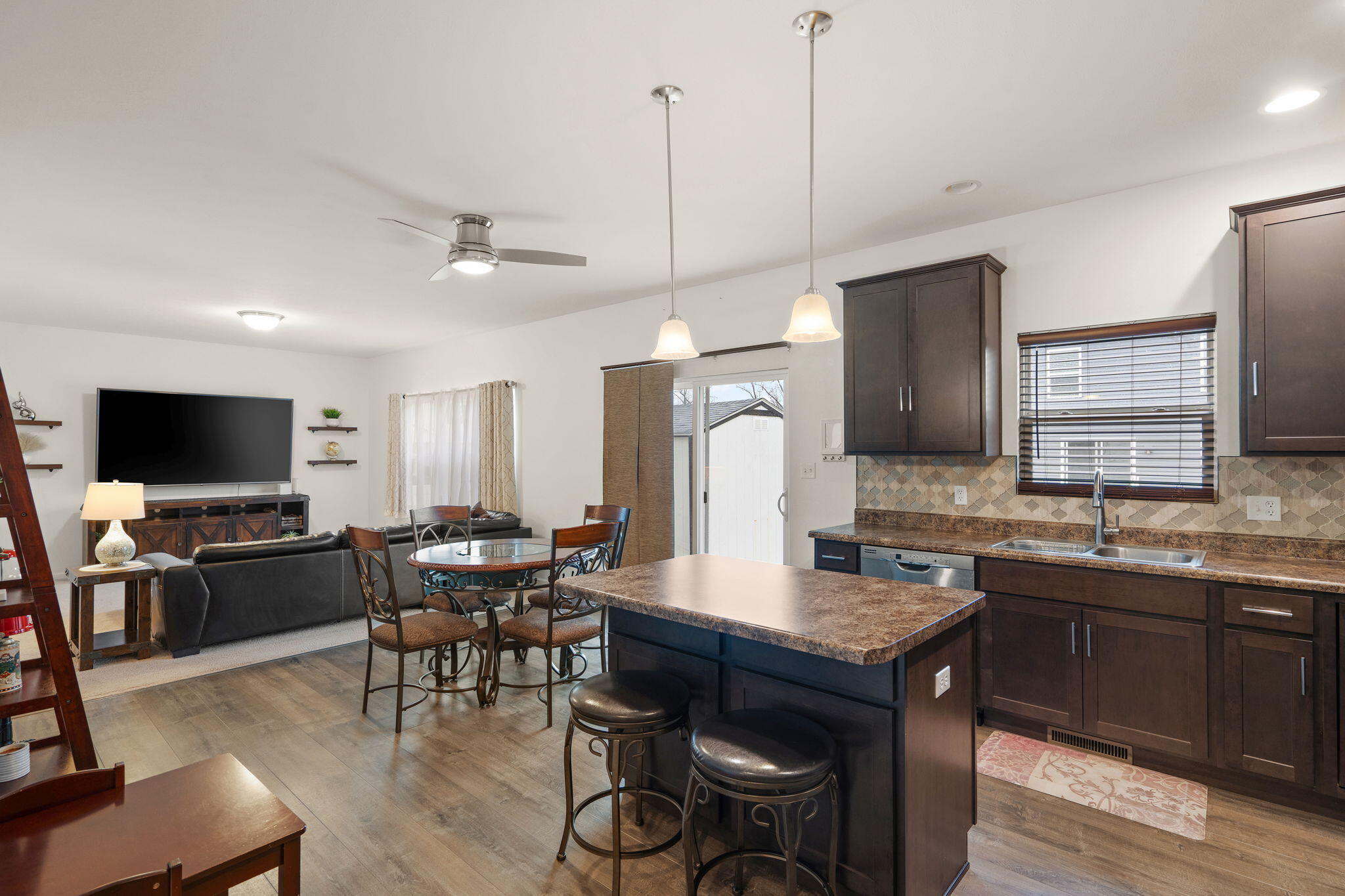 2434 Jupiter Street Portage, IN 46368 - Photo 17 of 30 a open kitchen with stainless steel appliances granite countertop a sink a stove a dining table and chairs with wooden floor
