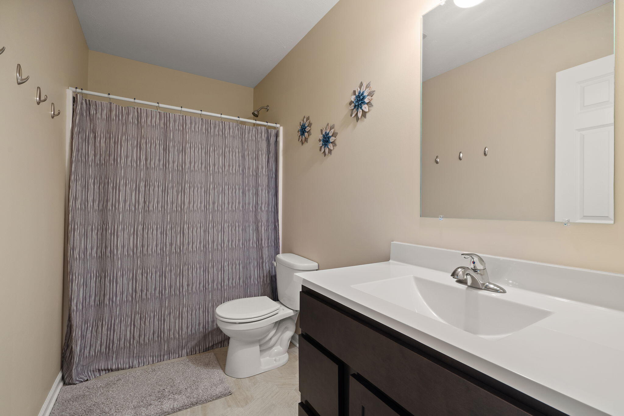 2434 Jupiter Street Portage, IN 46368 - Photo 22 of 30 a bathroom with a sink a toilet and shower curtain