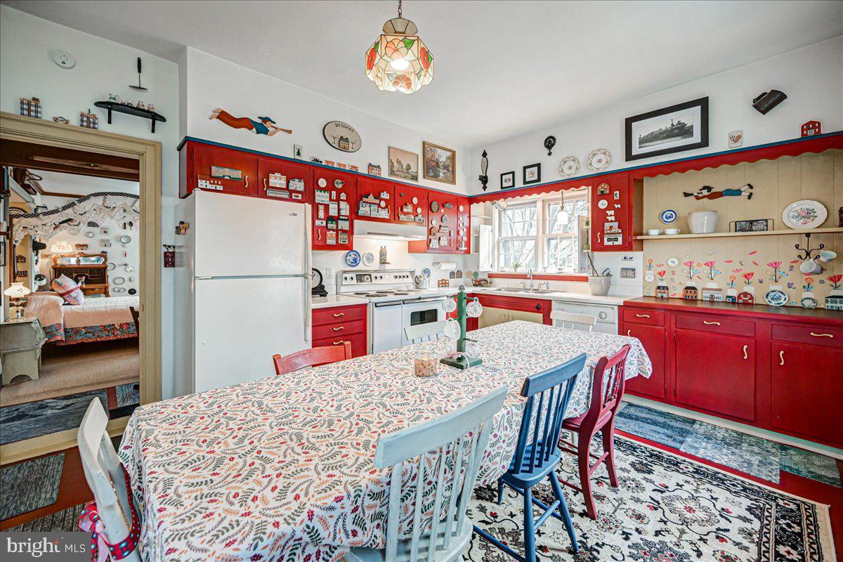 3459 Uniontown Road Westminster, MD 21158 - Photo 7 of 29 a kitchen with stainless steel appliances a refrigerator a stove a dining table and chairs with wooden floor