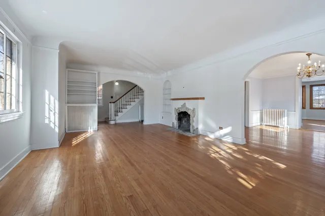a view of empty room with wooden floor and fireplace