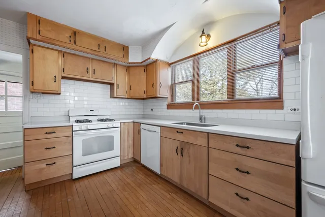 a kitchen with granite countertop white cabinets and white appliances