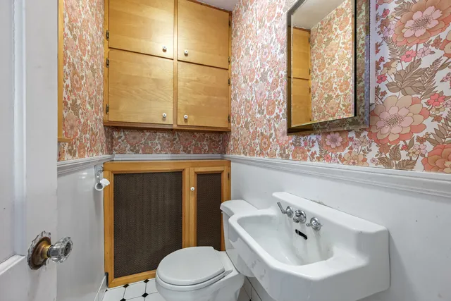 a bathroom with a sink and mirror with toilet
