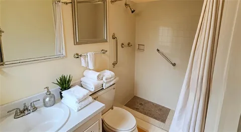 a bathroom with a sink a toilet and shower curtain