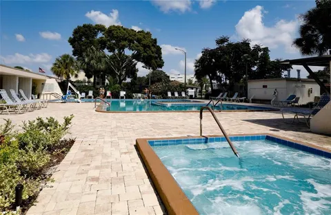 a swimming pool with a bench and trees in the background