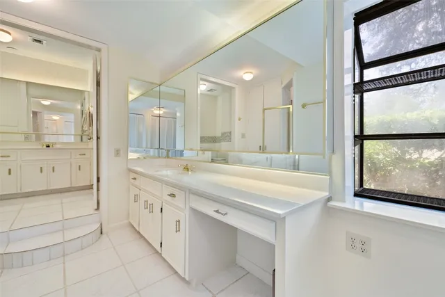 a bathroom with a granite countertop sink mirror and a shower