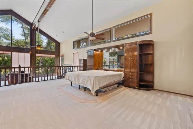 a spacious bedroom with a bed and a large window