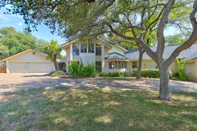 a front view of a house with yard and tree