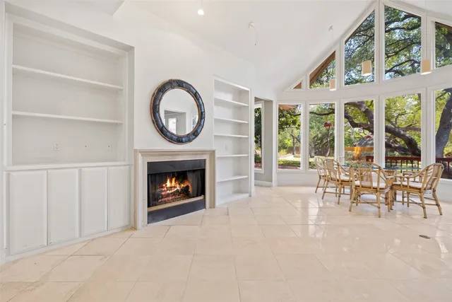 a living room with furniture a fireplace and a large window