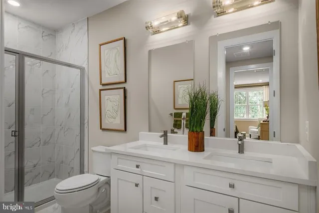 a bathroom with a double vanity sink toilet and shower