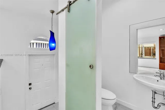 a bathroom with a granite countertop sink a toilet and shower