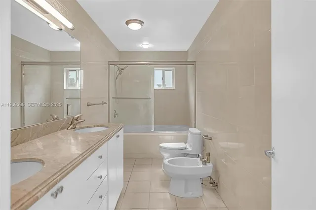 a bathroom with a granite countertop sink a toilet and bathtub