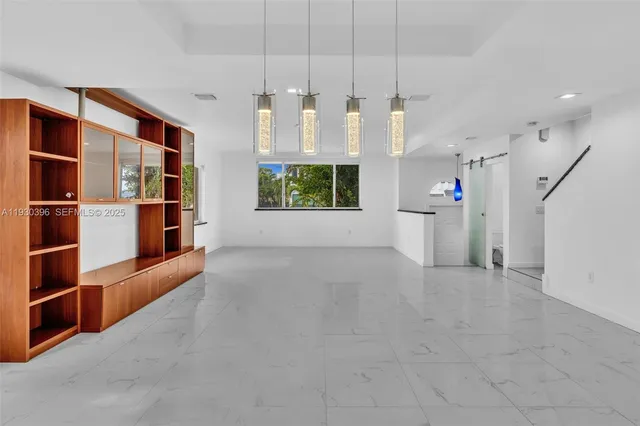 a view of an empty room with a window and cabinet