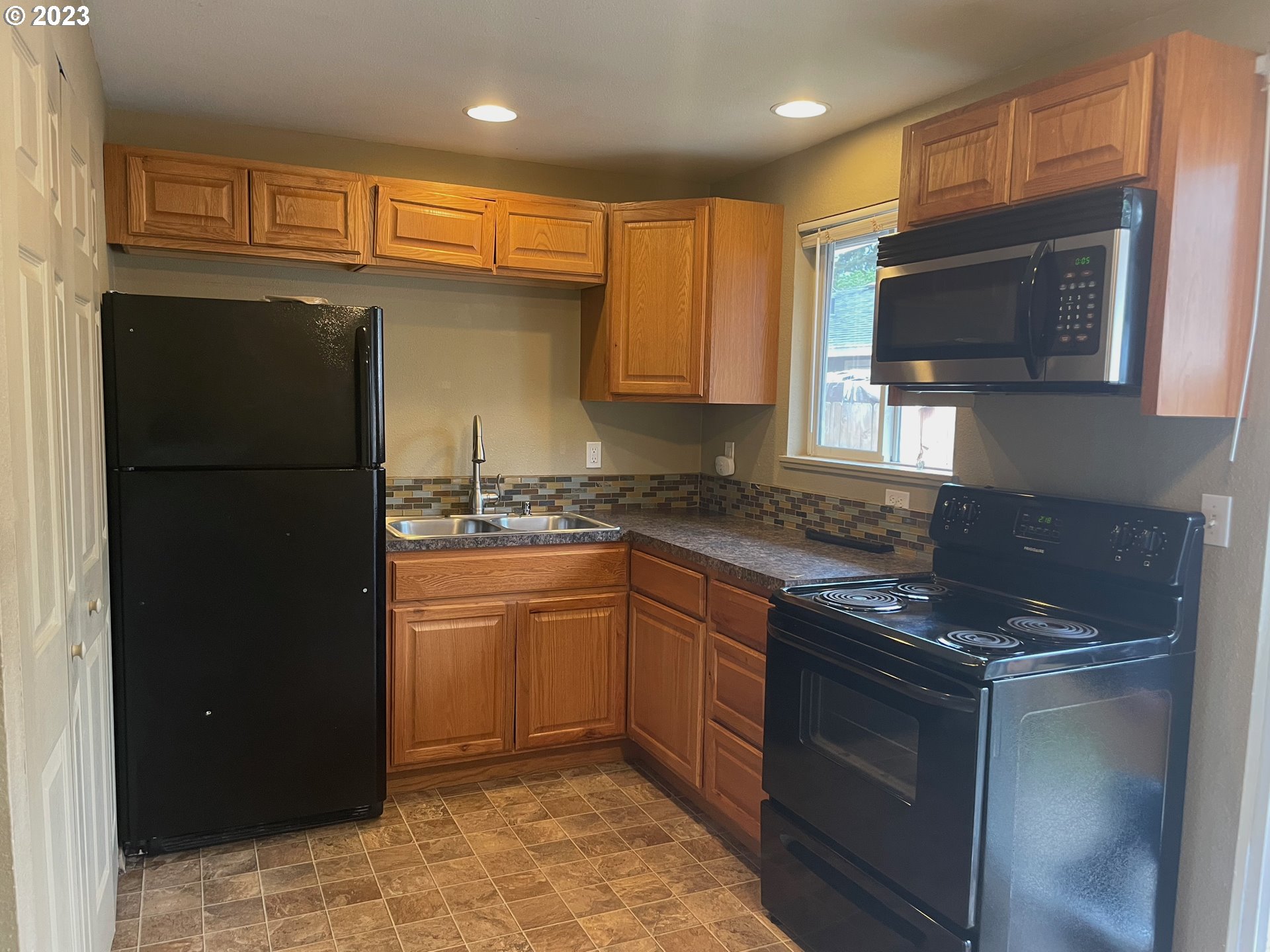 3205 W Street Vancouver, WA 98663 - Photo 3 of 6 a kitchen with stainless steel appliances granite countertop a refrigerator and a stove top oven