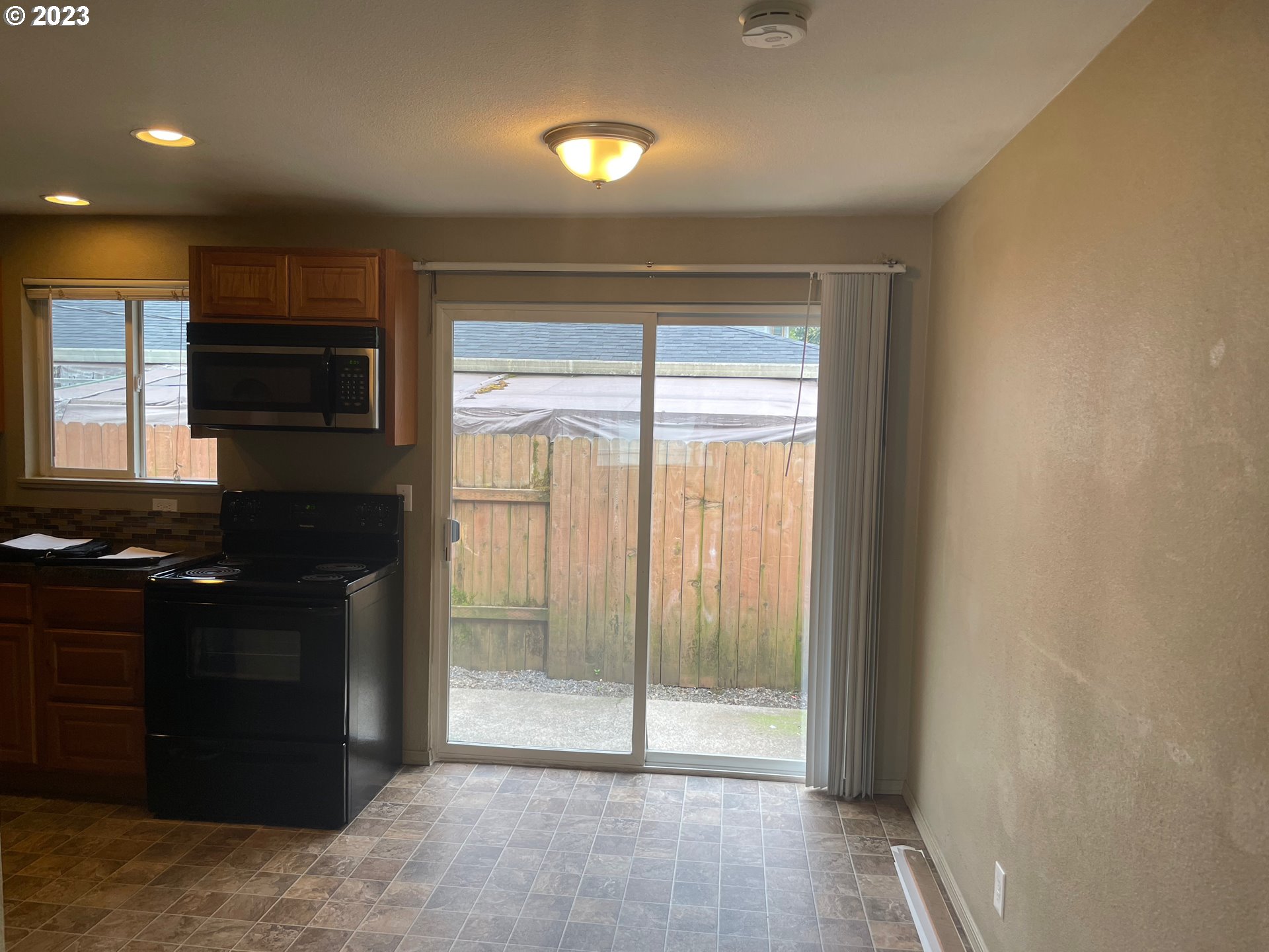 3205 W Street Vancouver, WA 98663 - Photo 4 of 6 a kitchen with granite countertop a refrigerator and a stove top oven