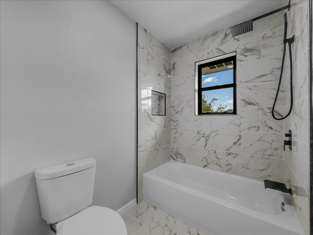 136 Southwest Rand Drive Burleson, TX 76028 - Photo 11 of 25 a bathroom with a toilet and a bathtub