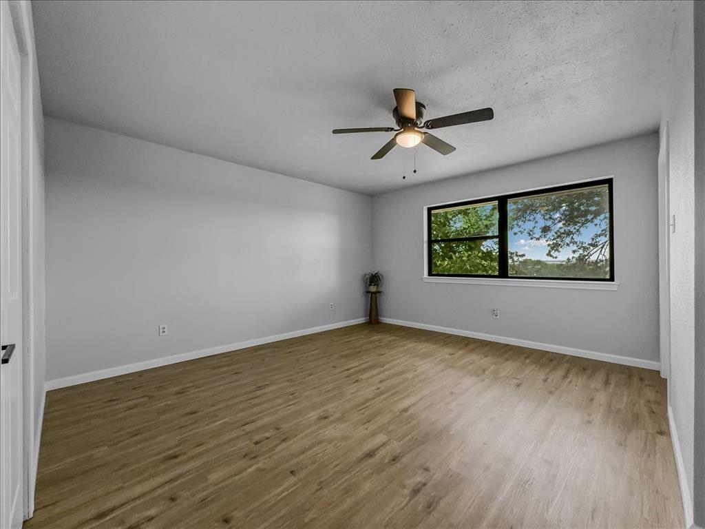 136 Southwest Rand Drive Burleson, TX 76028 - Photo 13 of 25 a view of empty room with wooden floor and fan