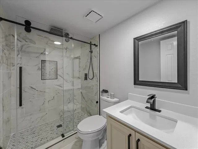 a bathroom with a sink a toilet and shower