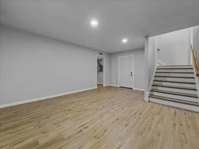 an empty room with wooden floor and white walls
