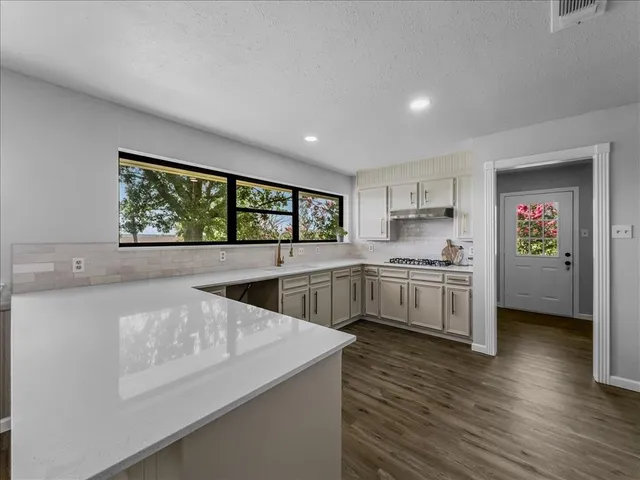 a large white kitchen with a large window