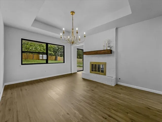 a view of an empty room with a fireplace and a window